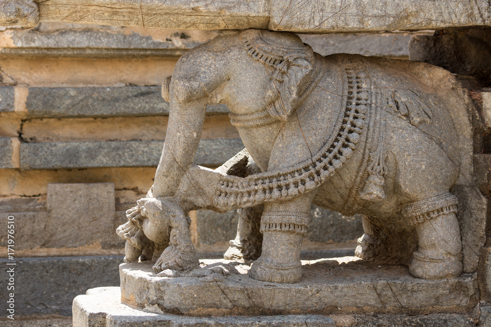 Mysore, India - October 27, 2013: Closeup of brown stone elephant statue supporting part of the Trikuta shrine at Chennakesava Temple in Somanathpur.