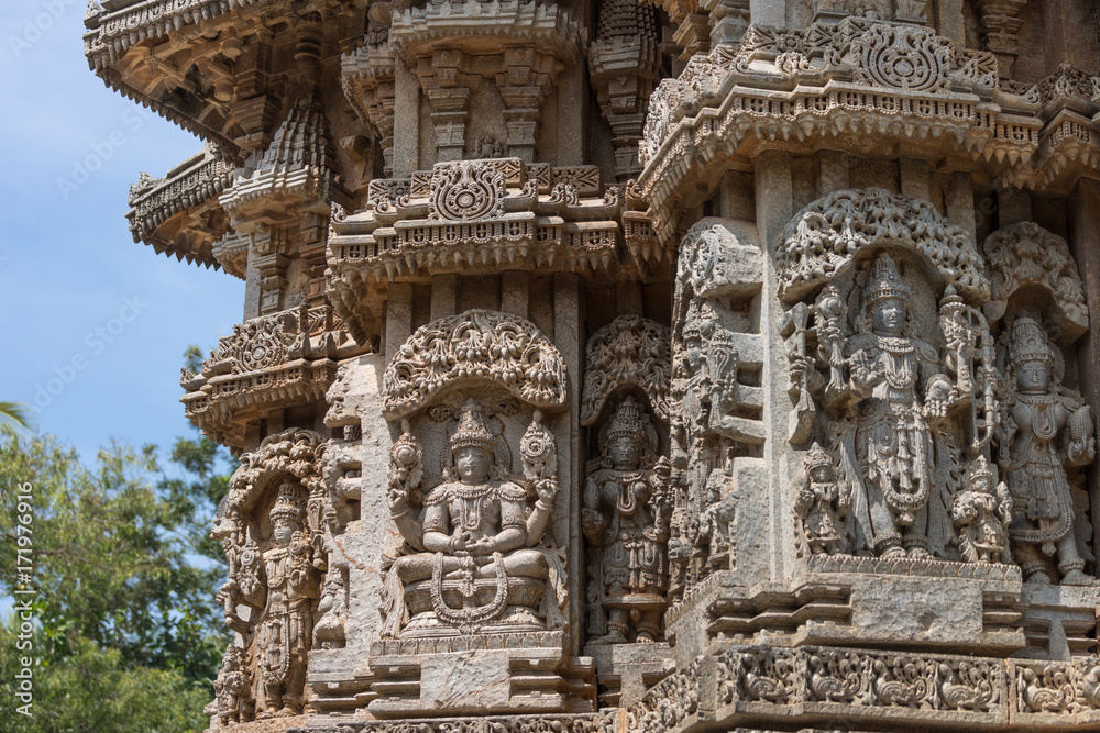 Mysore, India - October 27, 2013: Several brown stone, well preserved Lord Vishnu in full regalia statues on outside wall of Trikuta shrine. 