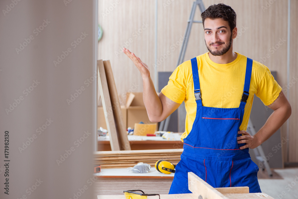 Young repairman carpenter working cutting wood Young repairman carpenter working cutting wood