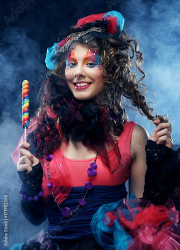 woman with creative make-up in doll style with candy. photo