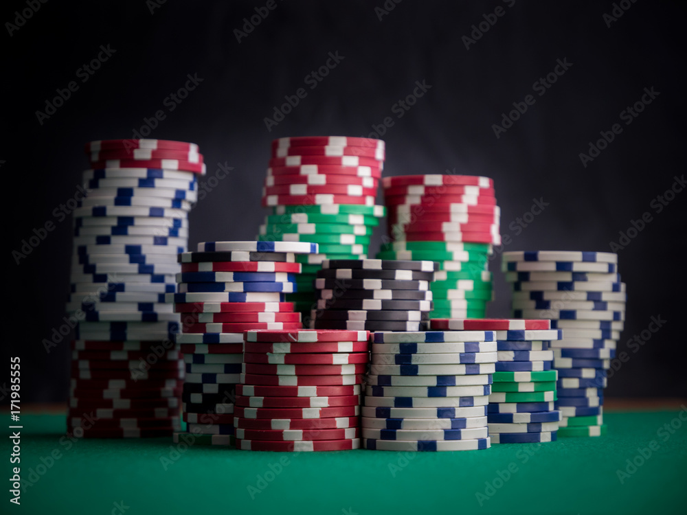 stacks of casino chips on green table and black background stacks of casino chips on green table and black background