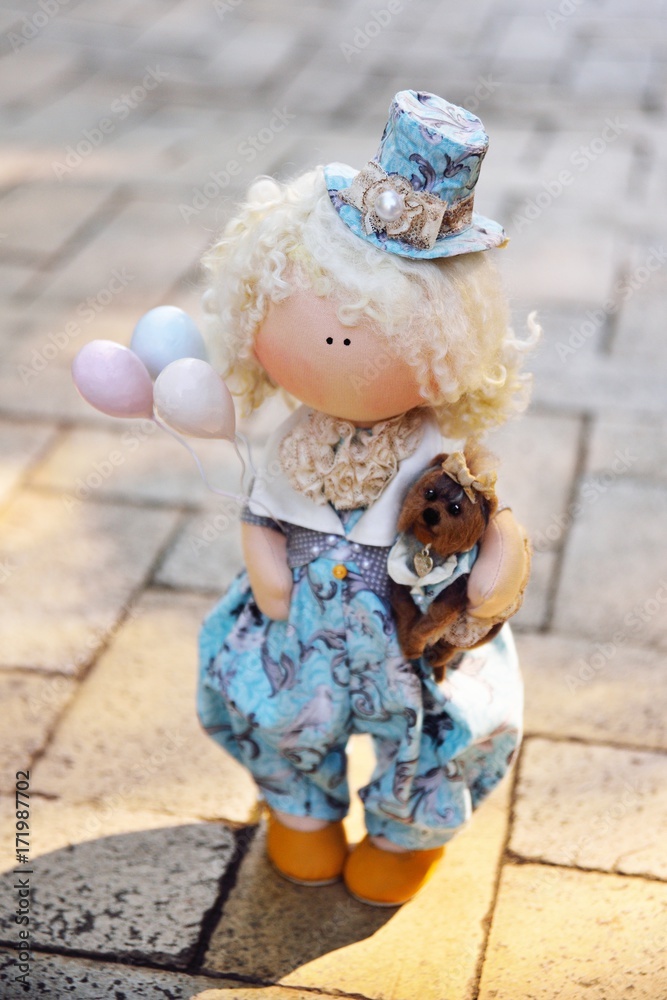 A handmade doll holds balloons and a small dog. Nostalgia, magic, kindness, childhood, dreams A handmade doll holds balloons and a small dog. Nostalgia, magic, kindness, childhood, dreams