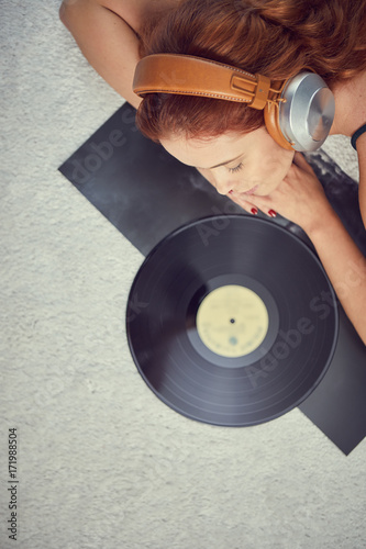 Woman listening vinyl at home. Evening atmosphere photo