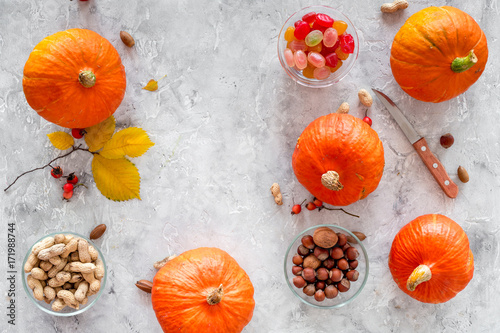 Pumpkin harvest. Pumpkins near nuts and autumn leaves on grey background top view copyspace photo