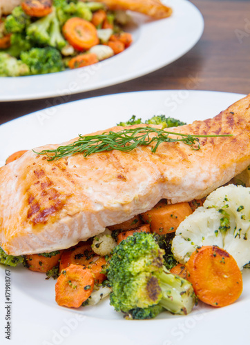 salmon fillet on a bed of broccoli, cauliflower and carrots
