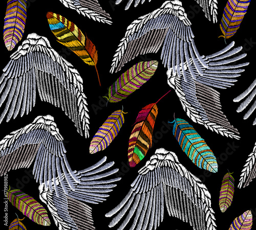 Embroidery angel wings and feathers seamless pattern. Beautiful bright tropical peacock feathers and angel wings embroidery. Fashion template for clothes, textiles, t-shirt design