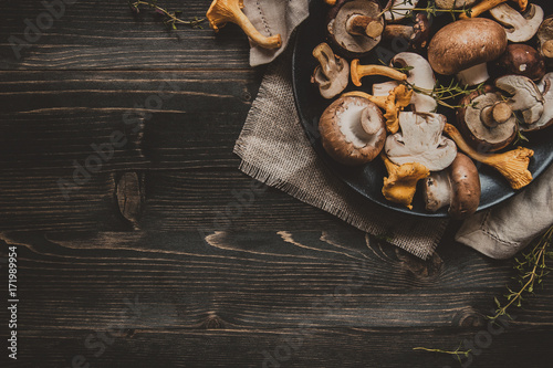 Fresh mixed forest mushrooms on the wooden black table photo