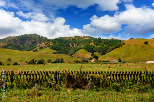 Big farm at the foot of green hills photo