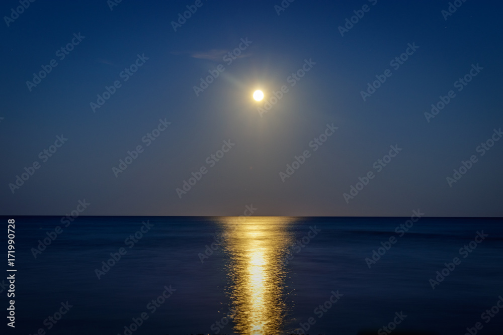Full moon over the pinarello bay with cool reflection on the sea Full moon over the pinarello bay with cool reflection on the sea