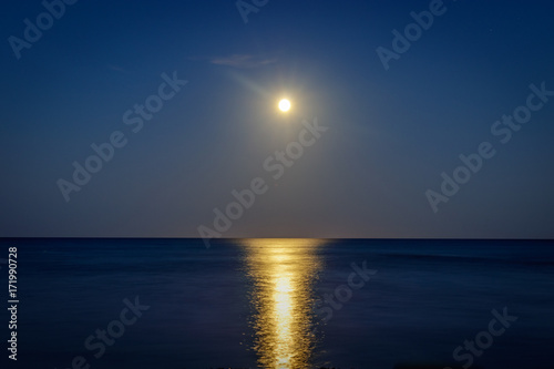 Full moon over the pinarello bay with cool reflection on the sea 
