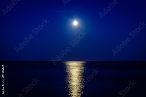Full moon over the pinarello bay with cool reflection on the sea 