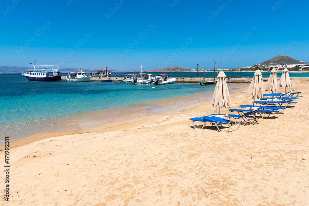 Sunbeds on sandy beach of Agia Anna ,one of the busiest beaches of Naxos. Cyclades, Greece.