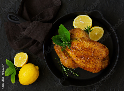 Baked whole chicken with lemon and herbs.