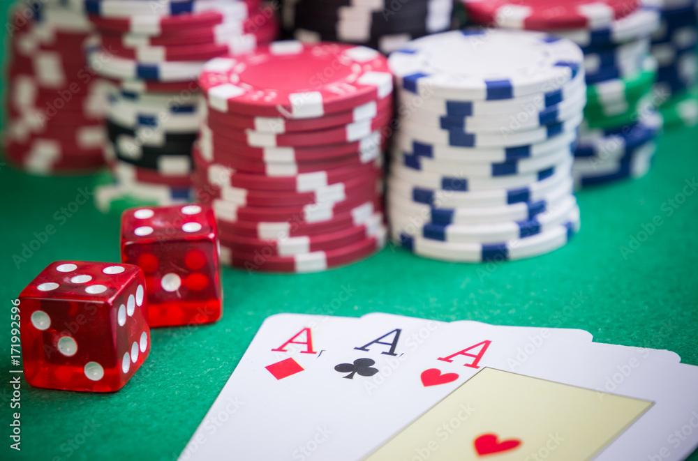 three aces and red cubes with poker chips on green table three aces and red cubes with poker chips on green table