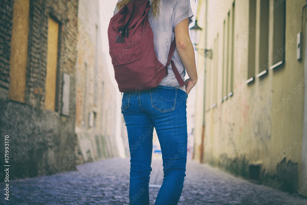 Tourist woman walks on the street in a old european town. Tourism and travel concept.