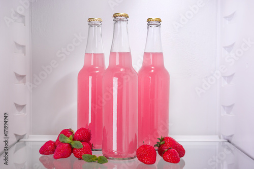 Bottles of fresh strawberry lemonade in fridge