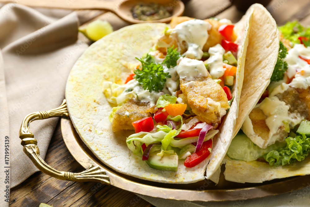 Metal tray with tasty fish tacos and sauce on table Metal tray with tasty fish tacos and sauce on table