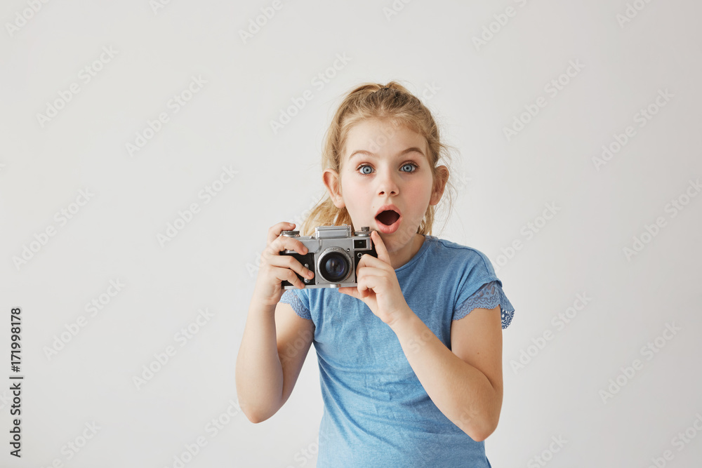 Little blond miss with blue eyes was taking family photo of parents with film camera when dad slipped and fell down. Child looking frightened that parent get hurt. Little blond miss with blue eyes was taking family photo of parents with film camera when dad slipped and fell down. Child looking frightened that parent get hurt.