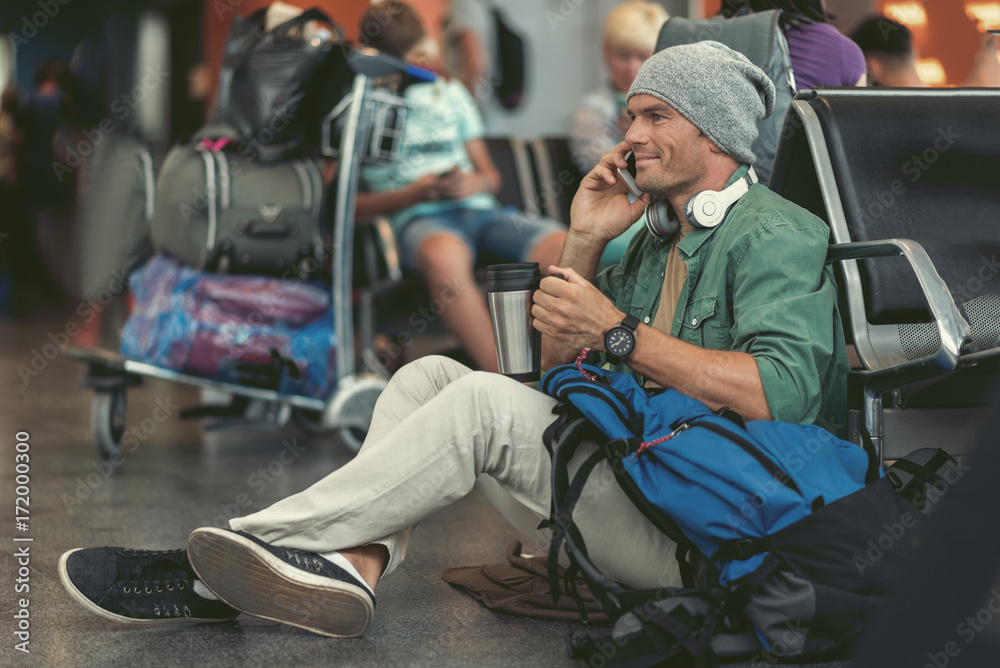 Cheerful man is calling using smartphone