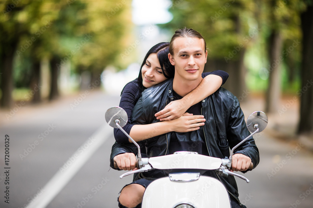 Couple in love riding a motorbike. Handsome guy and young sexy woman travel hug.