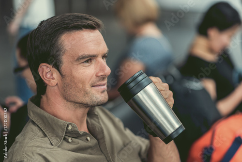 Cheerful cute guy is enjoying his beverage