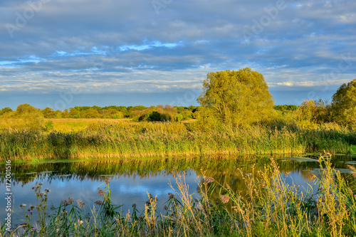 Colorful autumn landscape with a river and clouds