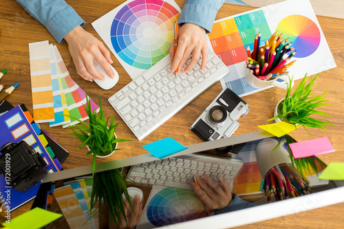 Young cute Graphic designer using graphics tablet to do his work at desk