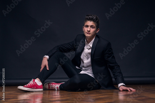 one young teenage boy, sitting posing model