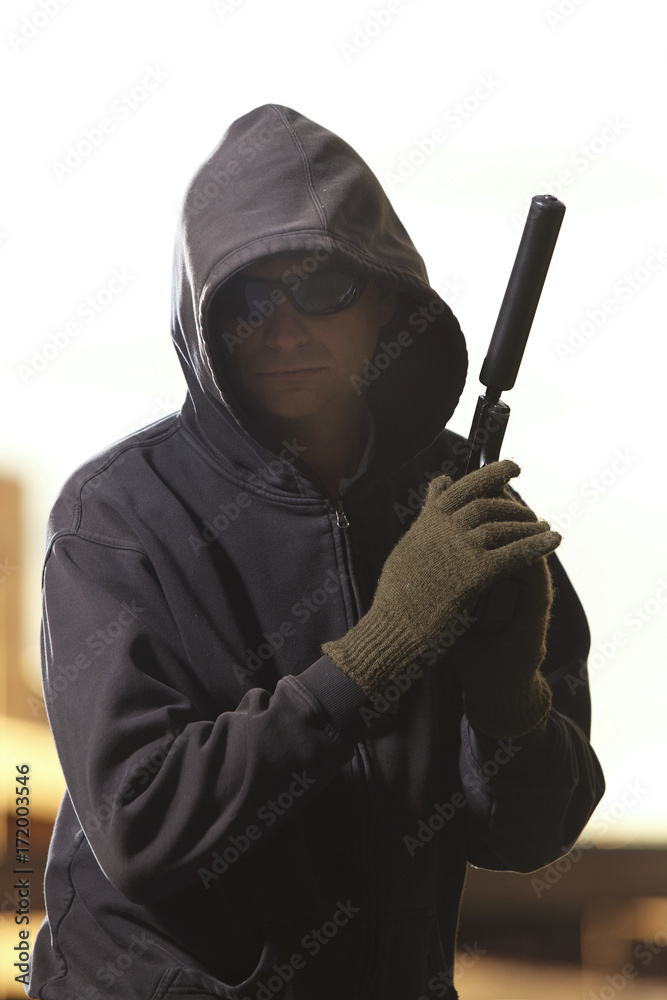 Man armed with pistol with silencer preparing for attack on public Man armed with pistol with silencer preparing for attack on public