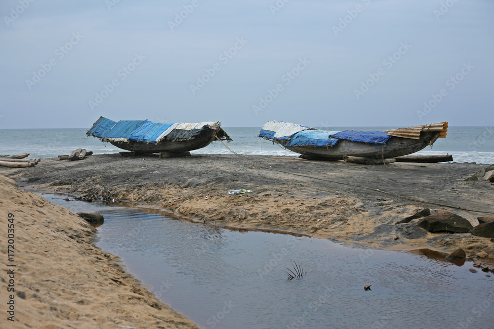 Boats covered with tarpaulin on the beach near Varkala, Southern India Boats covered with tarpaulin on the beach near Varkala, Southern India