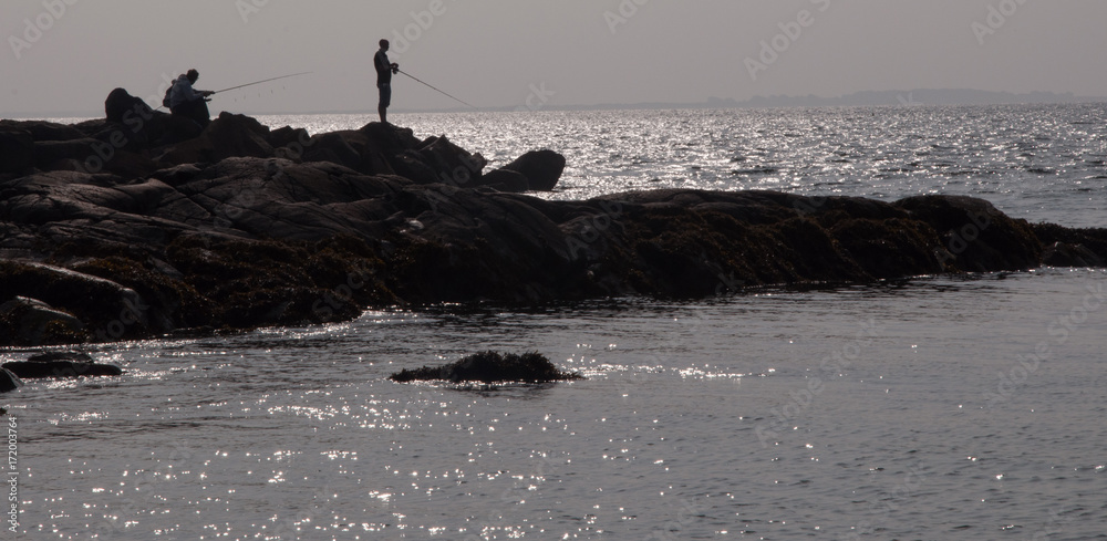 Fishing at sunset off rocks at Irish coast 