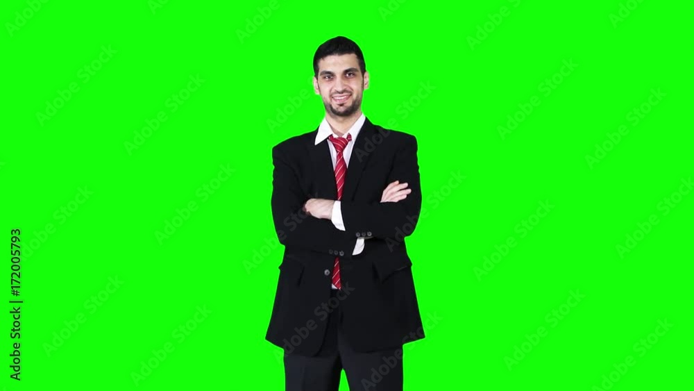 Successful Caucasian businessman standing in the studio while folded hands and smiling at the camera in front of green screen background Successful Caucasian businessman standing in the studio while folded hands and smiling at the camera in front of green screen background