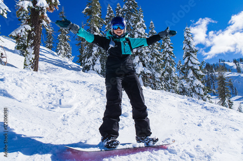 Young caucasian woman on snowboard laughs and celebrates