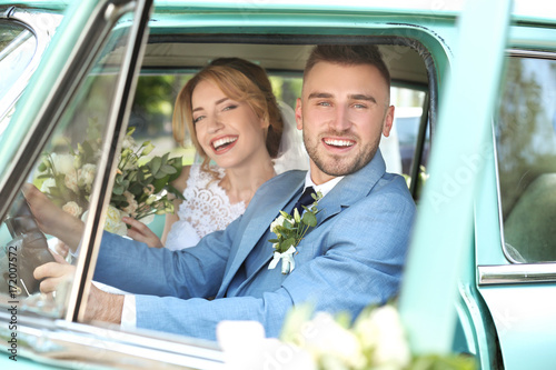 Happy wedding couple in car