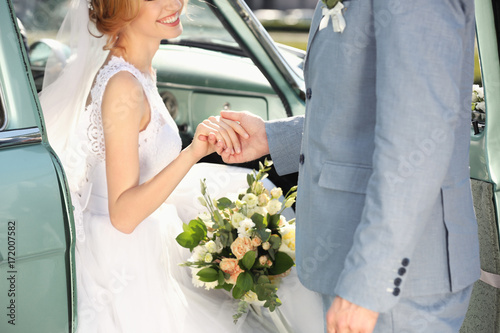 Happy wedding couple and car