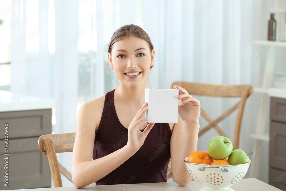 Beautiful young woman with biologically active supplement sitting at table. Diet concept Beautiful young woman with biologically active supplement sitting at table. Diet concept