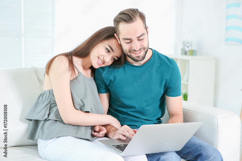 Young couple searching information using laptop at home Young couple searching information using laptop at home