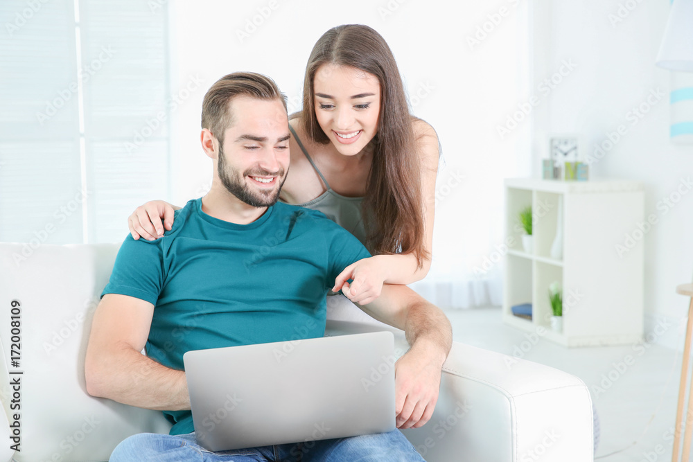 Young couple searching information using laptop at home Young couple searching information using laptop at home