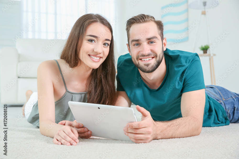Fototapeta premium Young couple searching information using tablet at home