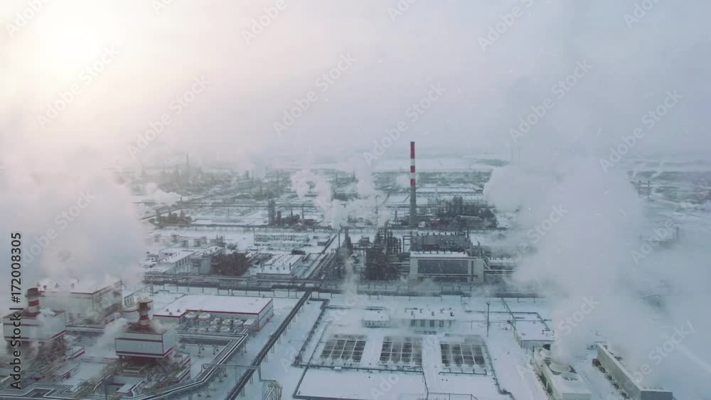 Storm weather and snowfall. Aerial view of gas processing plant at winter time. Cold morning at industrial zone