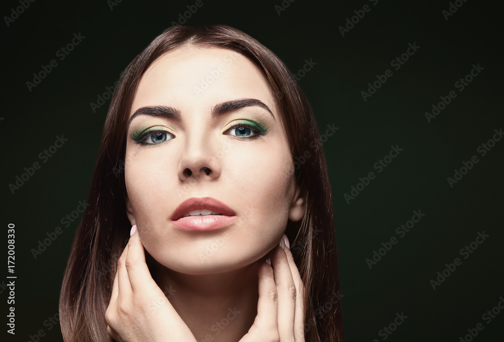 Young beautiful woman with fancy green makeup on dark background Young beautiful woman with fancy green makeup on dark background