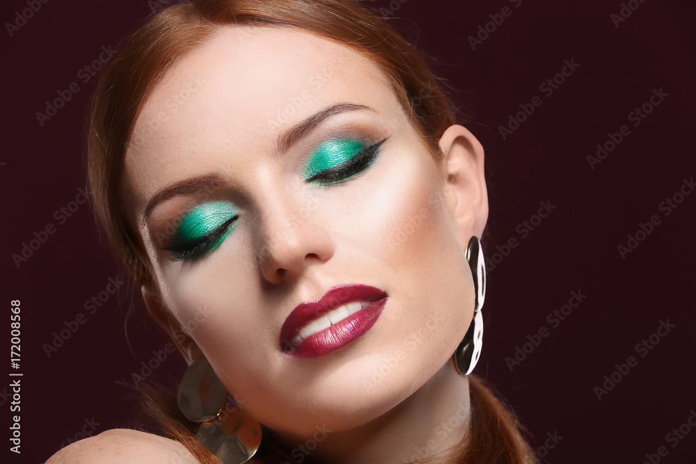 Beautiful redhead woman with bright green makeup on dark background Beautiful redhead woman with bright green makeup on dark background
