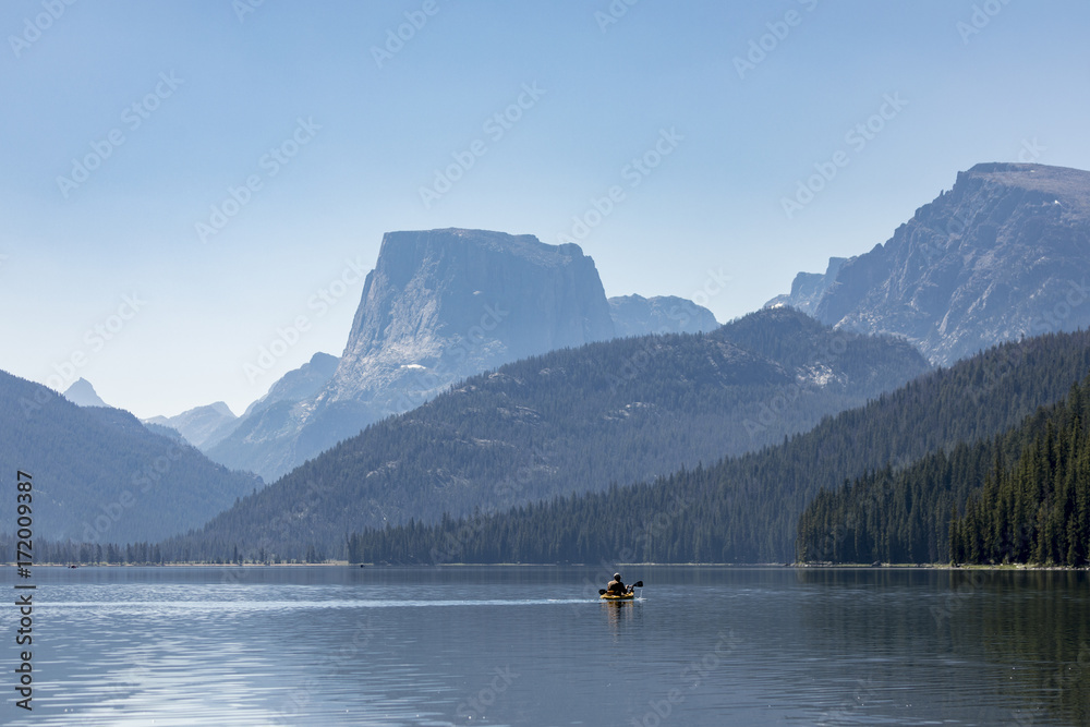 kayaker paddling out on a beautiful mountain lake
