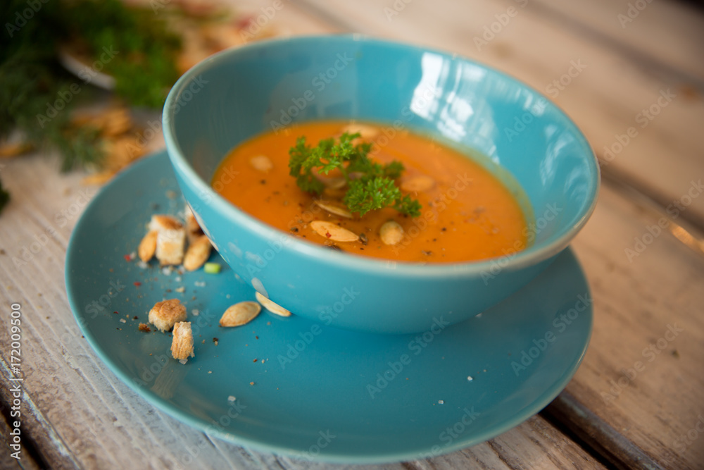 Squash soup served with parsley and pumpkin seeds / Autumn concept Squash soup served with parsley and pumpkin seeds / Autumn concept