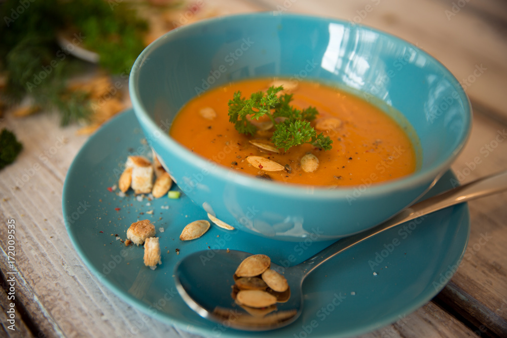 Pumpkin soup served with parsley and pumpkin seeds / Autumn concept Pumpkin soup served with parsley and pumpkin seeds / Autumn concept