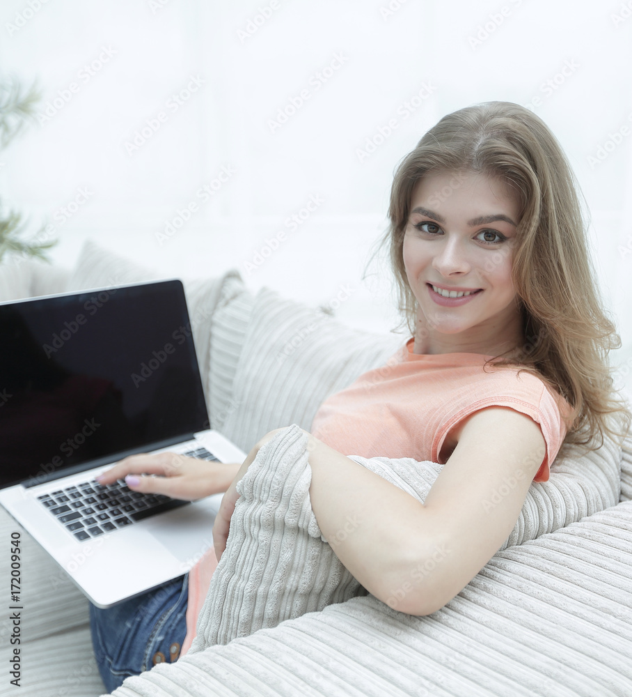 young woman working with laptop sitting on sofa young woman working with laptop sitting on sofa