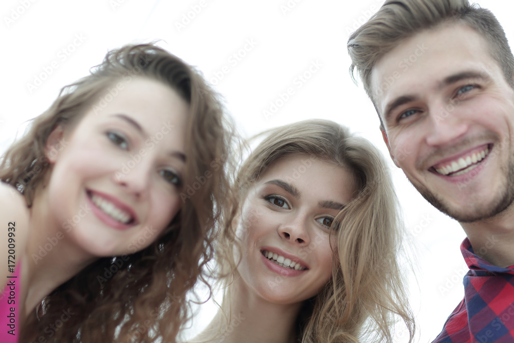 closeup of three young people smiling on white background closeup of three young people smiling on white background
