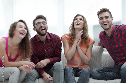 group of cheerful young people sitting on the couch. © ASDF