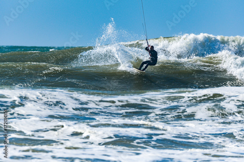 Kitesurfer riding ocean waves © homydesign