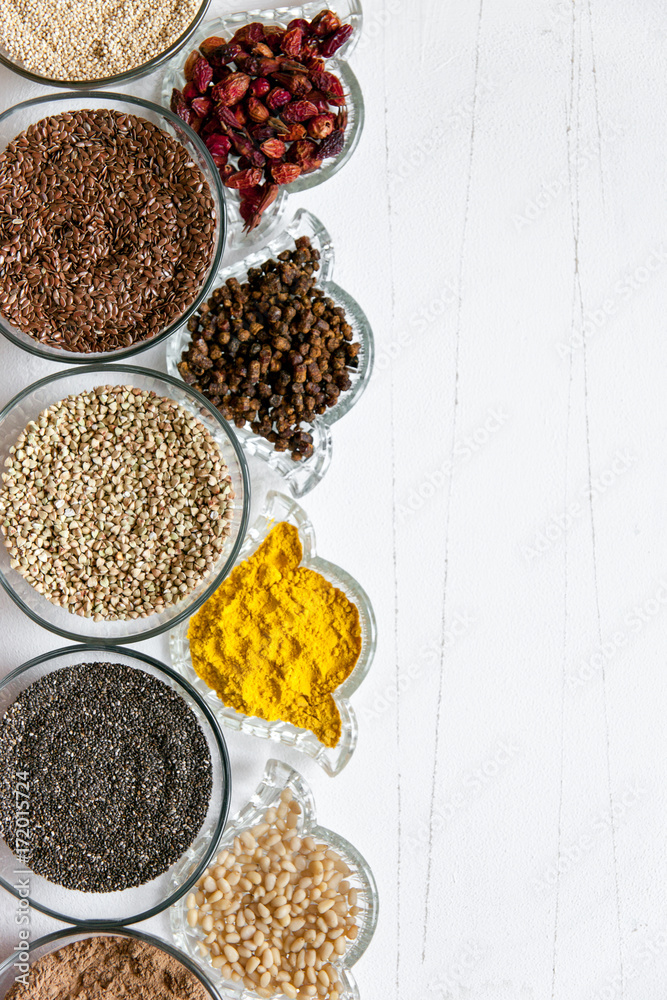 Superfoods in glassware on white background. Bright colorful flat lay of healthy food products with copy space.